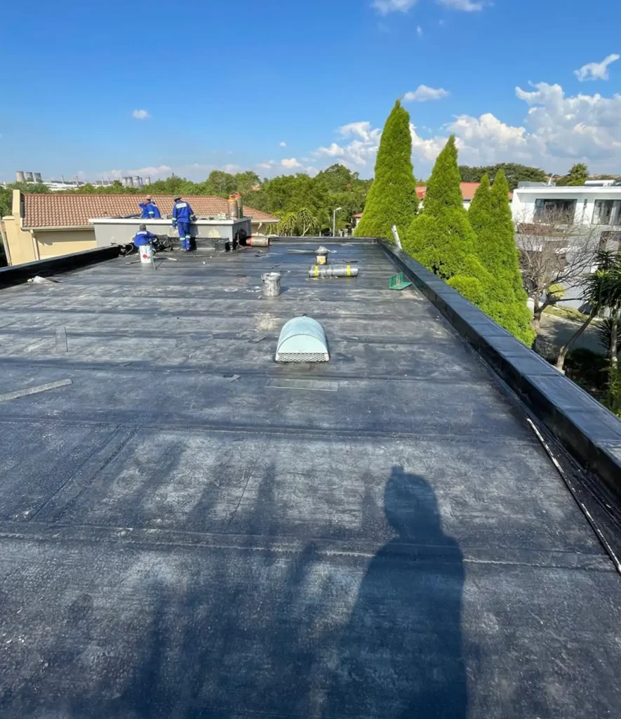 Torch-on waterproofing membrane being applied to an inverted roof and the drainage sized and fitted